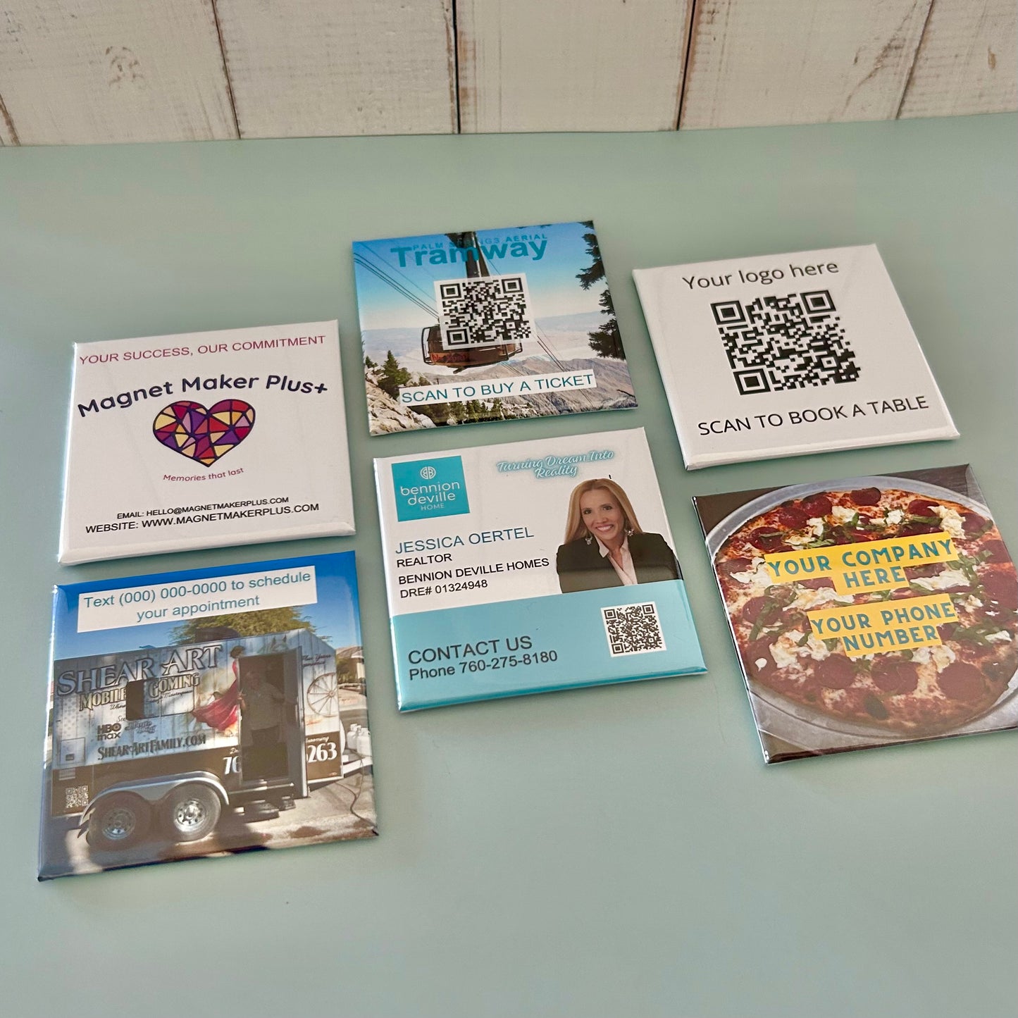 Collection of promotional business card magnets with various designs on a light surface.