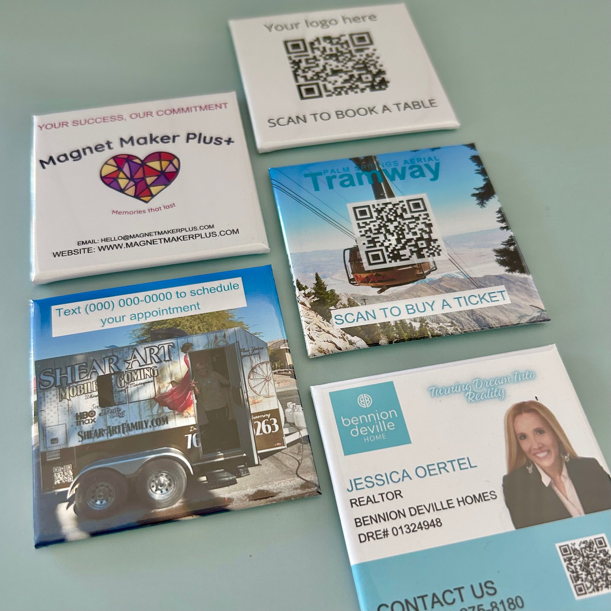 Collection of promotional business card magnets with QR codes on a gray background