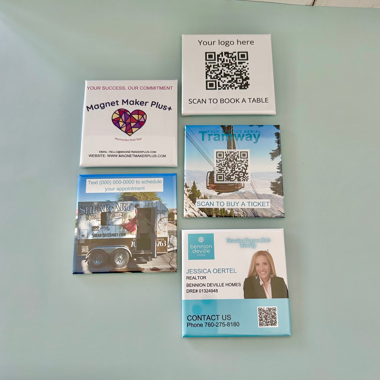 Collection of promotional card magnets with QR codes on a light gray background