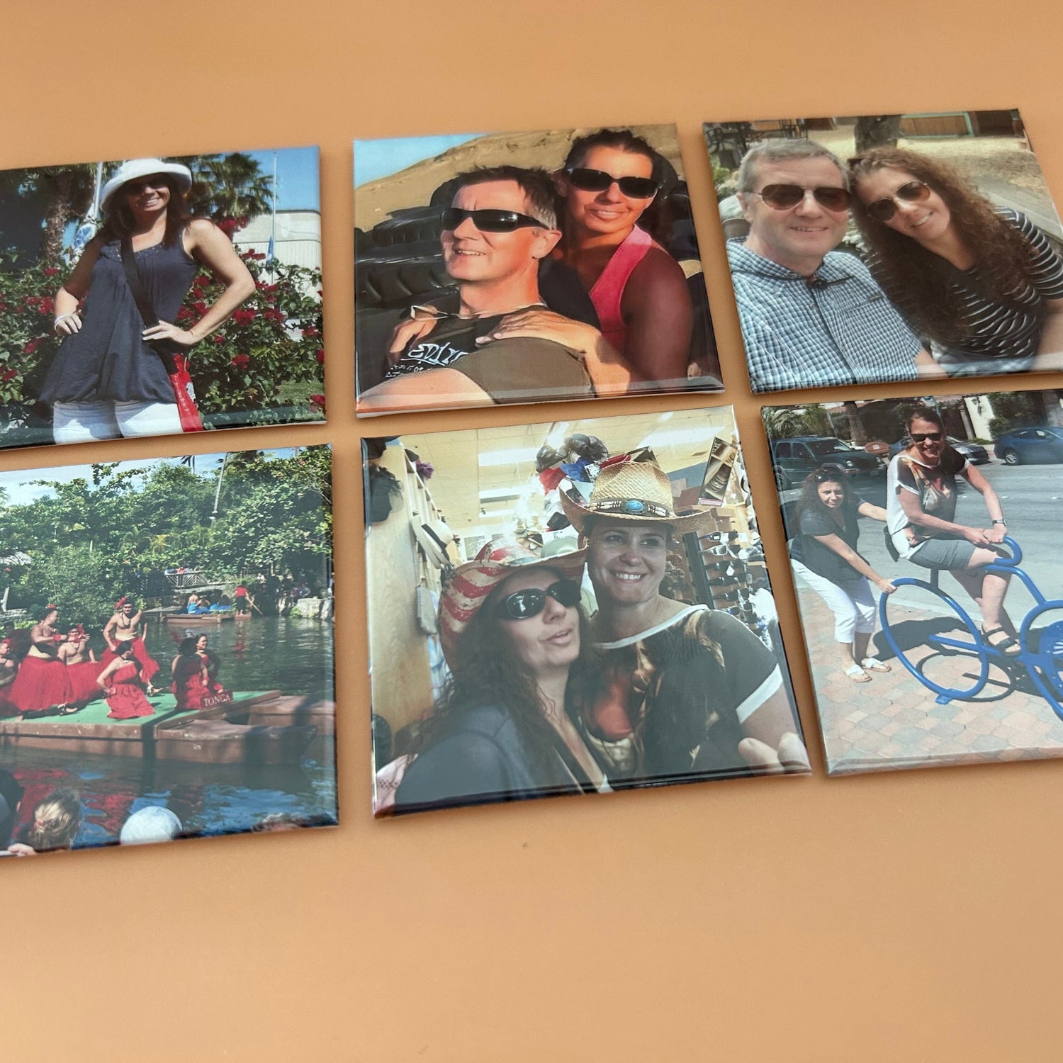 Six photo prints of people in various settings on a beige surface
