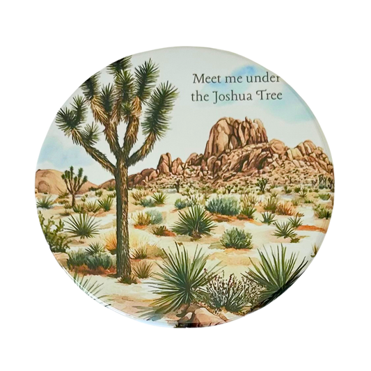 Square coaster featuring a watercolor desert landscape with a Joshua tree, yucca plants, boulder formations, and the text "Meet me under the Joshua Tree."