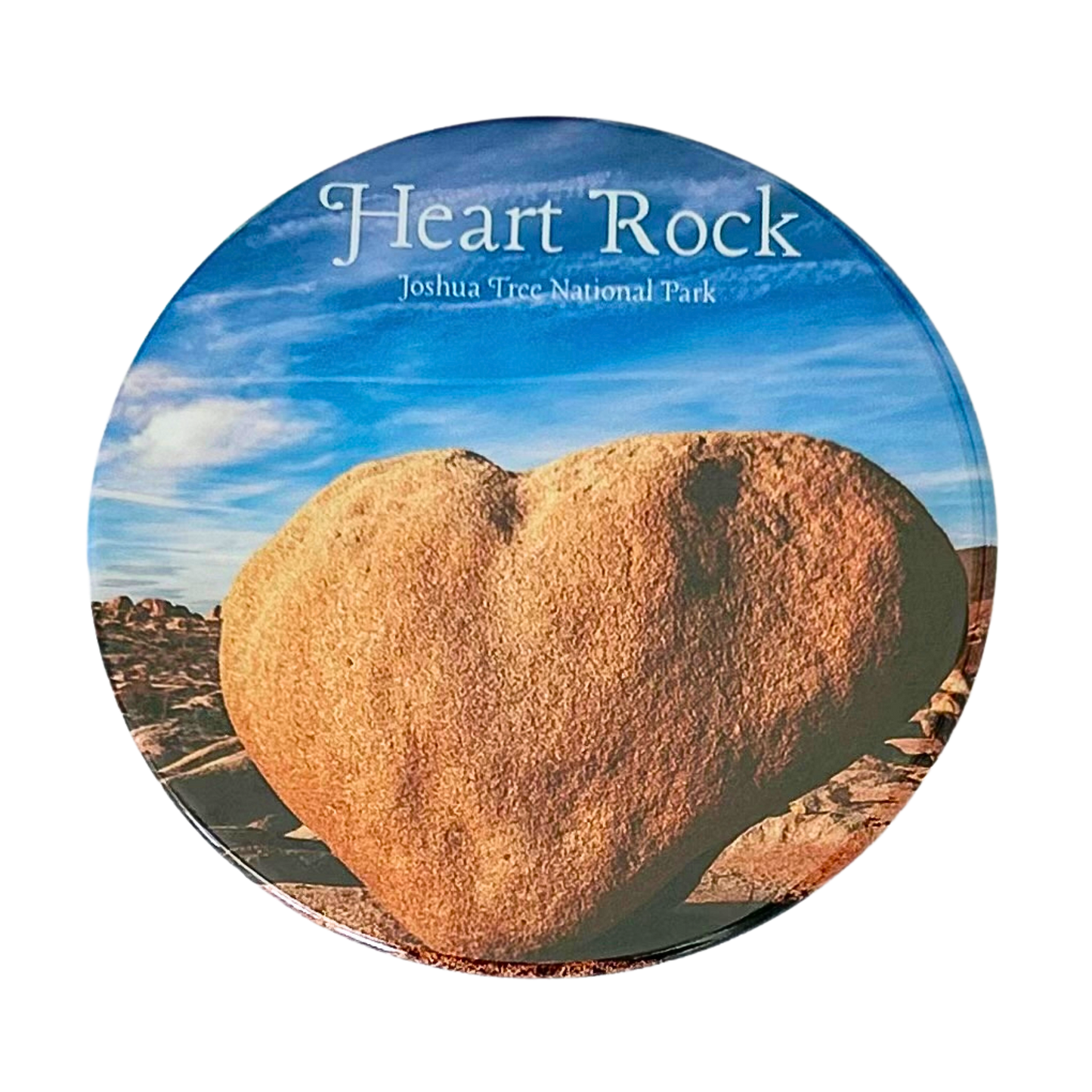 Square coaster featuring a photo of Heart Rock at Joshua Tree National Park — a large naturally heart-shaped granite boulder against a bright blue desert sky.