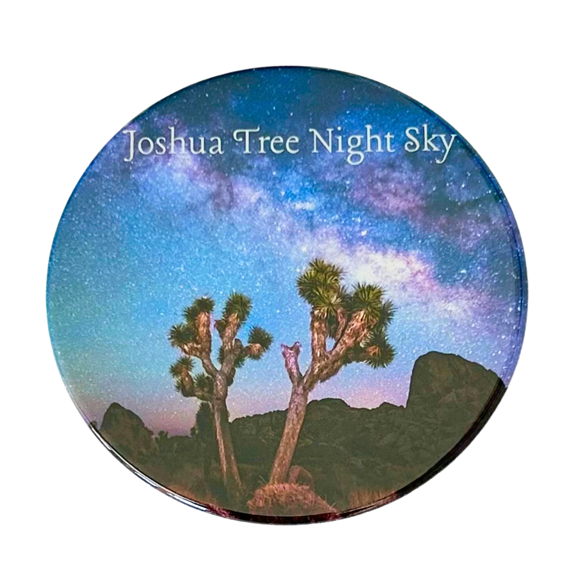 Square coaster featuring a photo of two Joshua trees silhouetted against a vivid Milky Way night sky with violet and blue hues over Joshua Tree National Park.