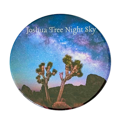 Square coaster featuring a photo of two Joshua trees silhouetted against a vivid Milky Way night sky with violet and blue hues over Joshua Tree National Park.