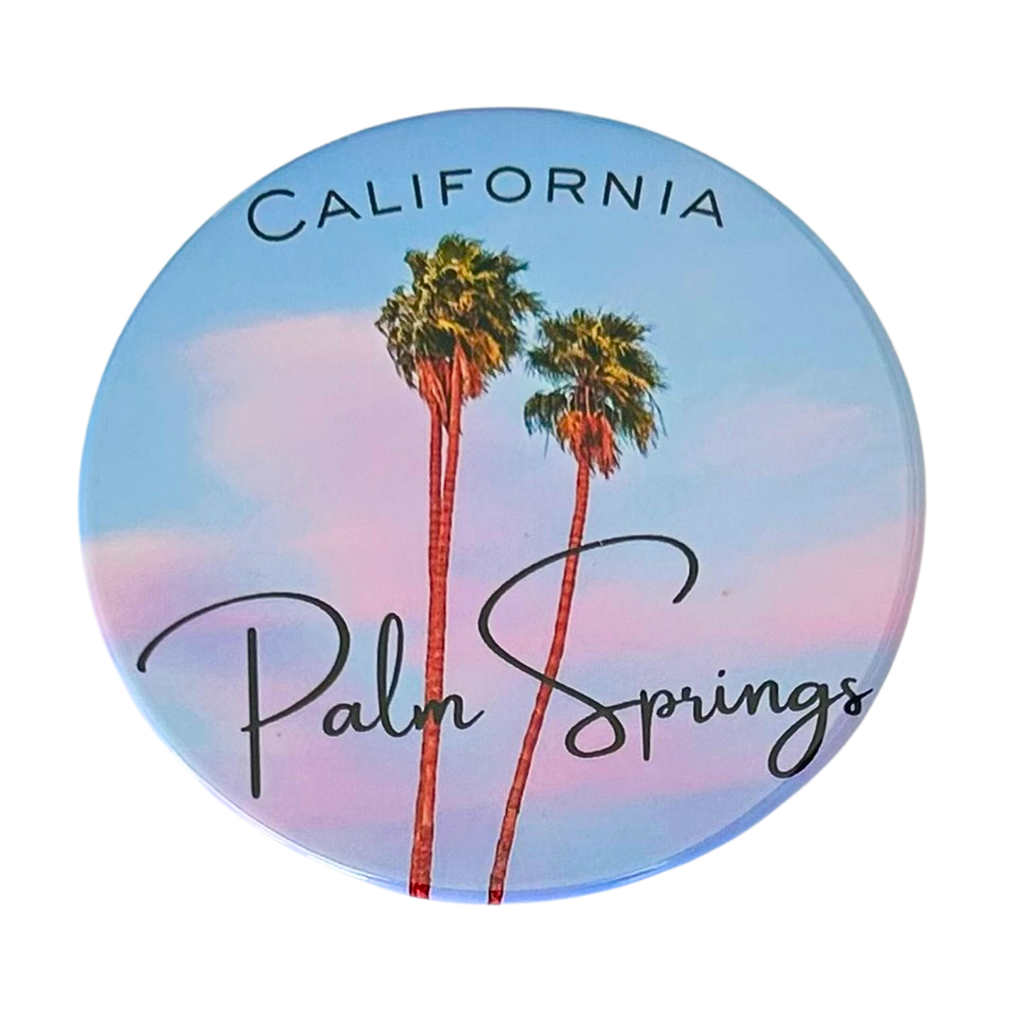 Round 3.5" Palm Springs California coaster featuring two tall palm trees against a soft blue and pink pastel sky, with "California" in block letters and "Palm Springs" in elegant script.