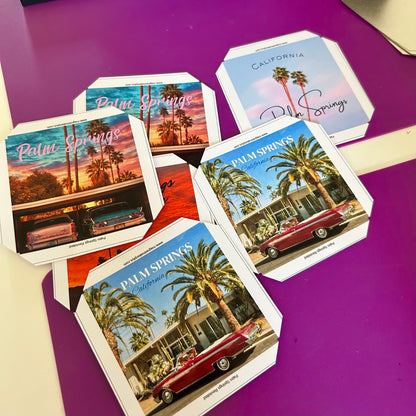 Set of magnets with Palm Springs-themed designs on a purple surface