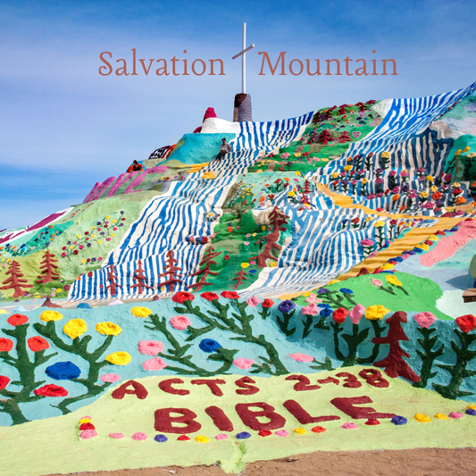Salvation Mountain magnet featuring colorful painted desert art installation with flowers, striped hills, and cross in California.